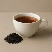 Weiße Porzellantasse mit Earl Grey Deluxe Tee von Mrs. Tea. Daneben Schwarzer Tee mit blauen Kornblumenblüten